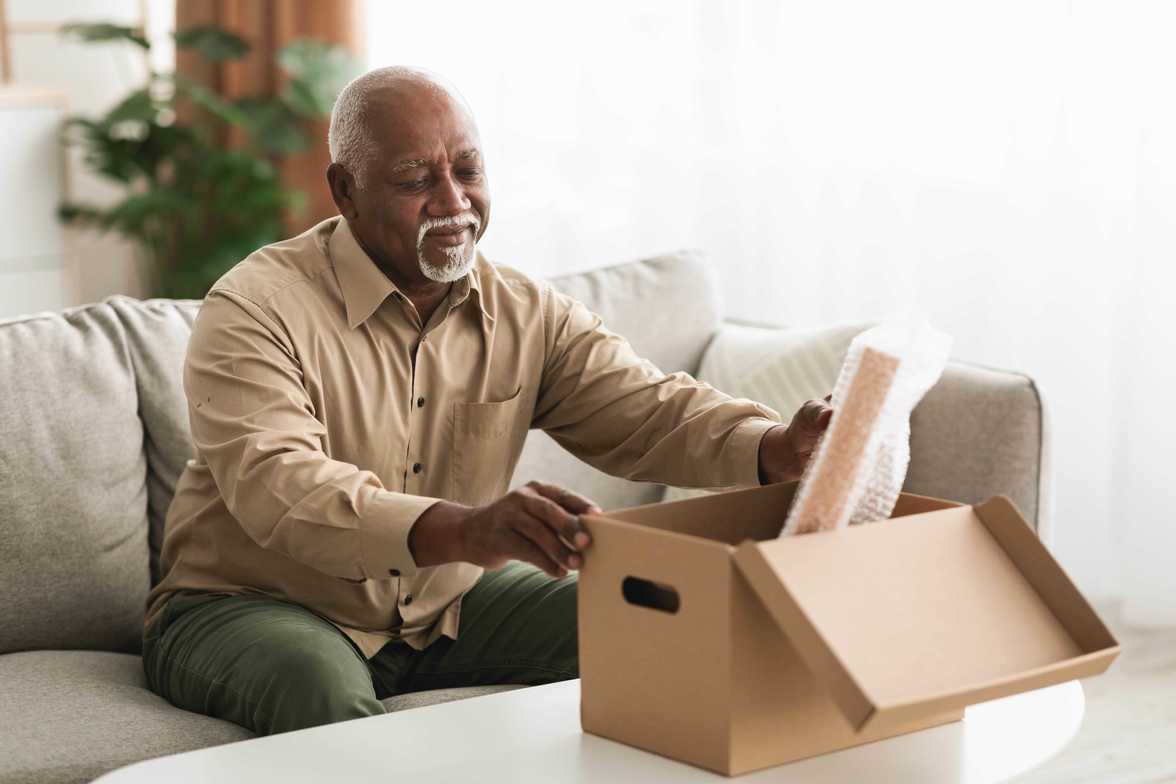 older adult going through box of items