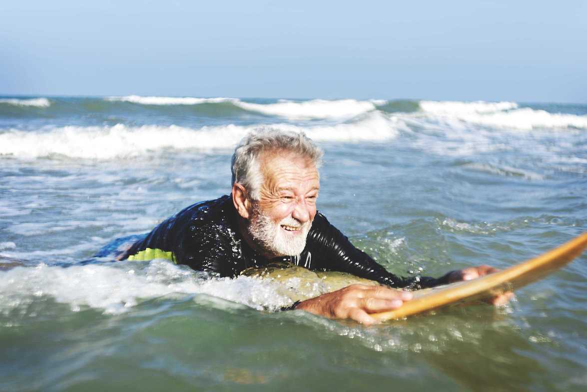 a senior man on a surfboard